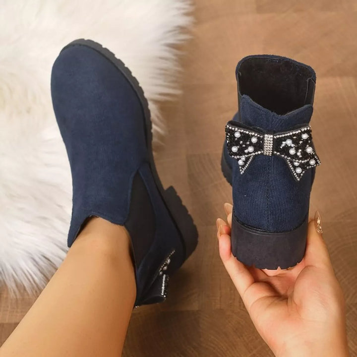 Navy Chelsea boots with the pearl bow at the back, back view