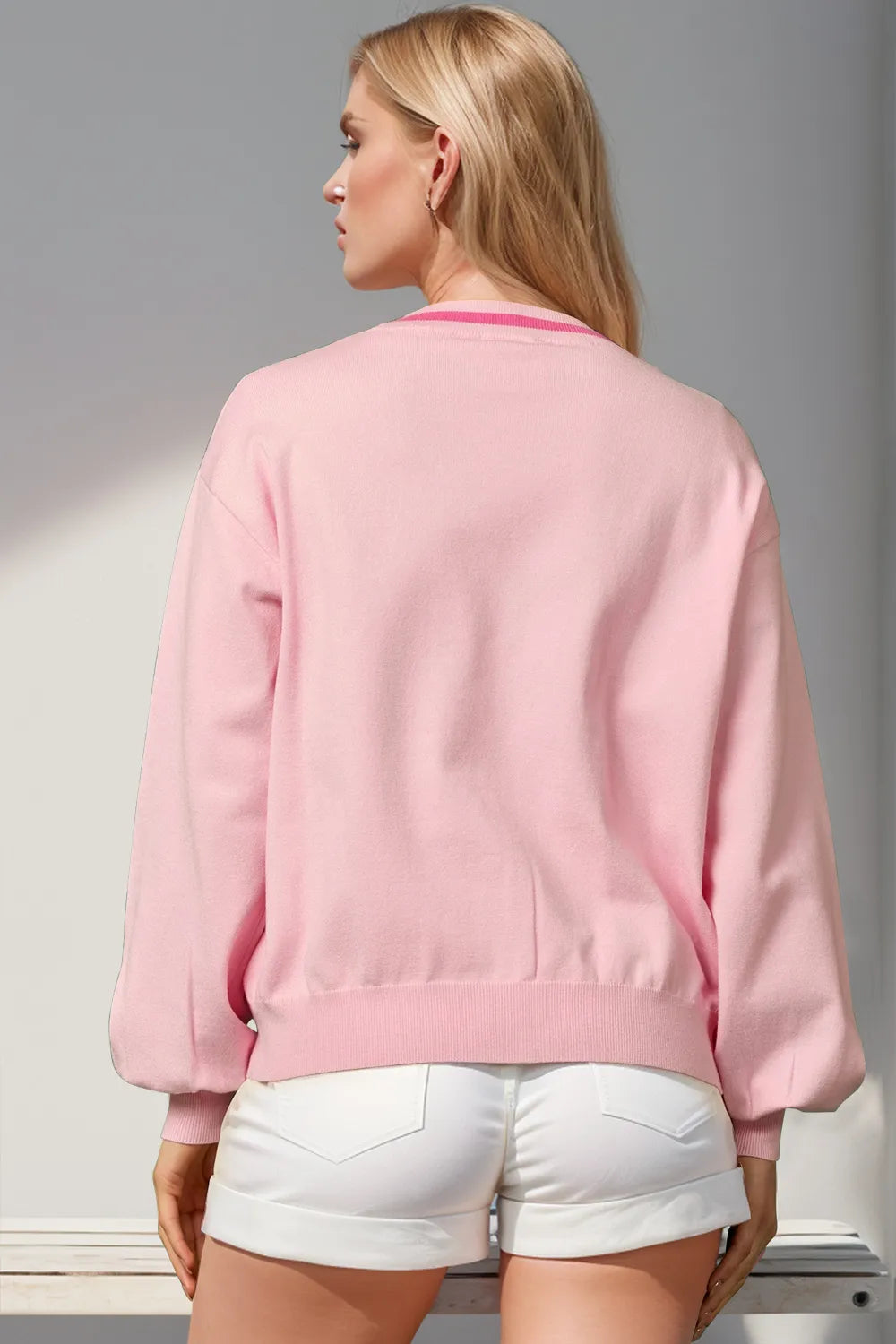 Back view of the blush pink V neck cardigan with ribbed trim
