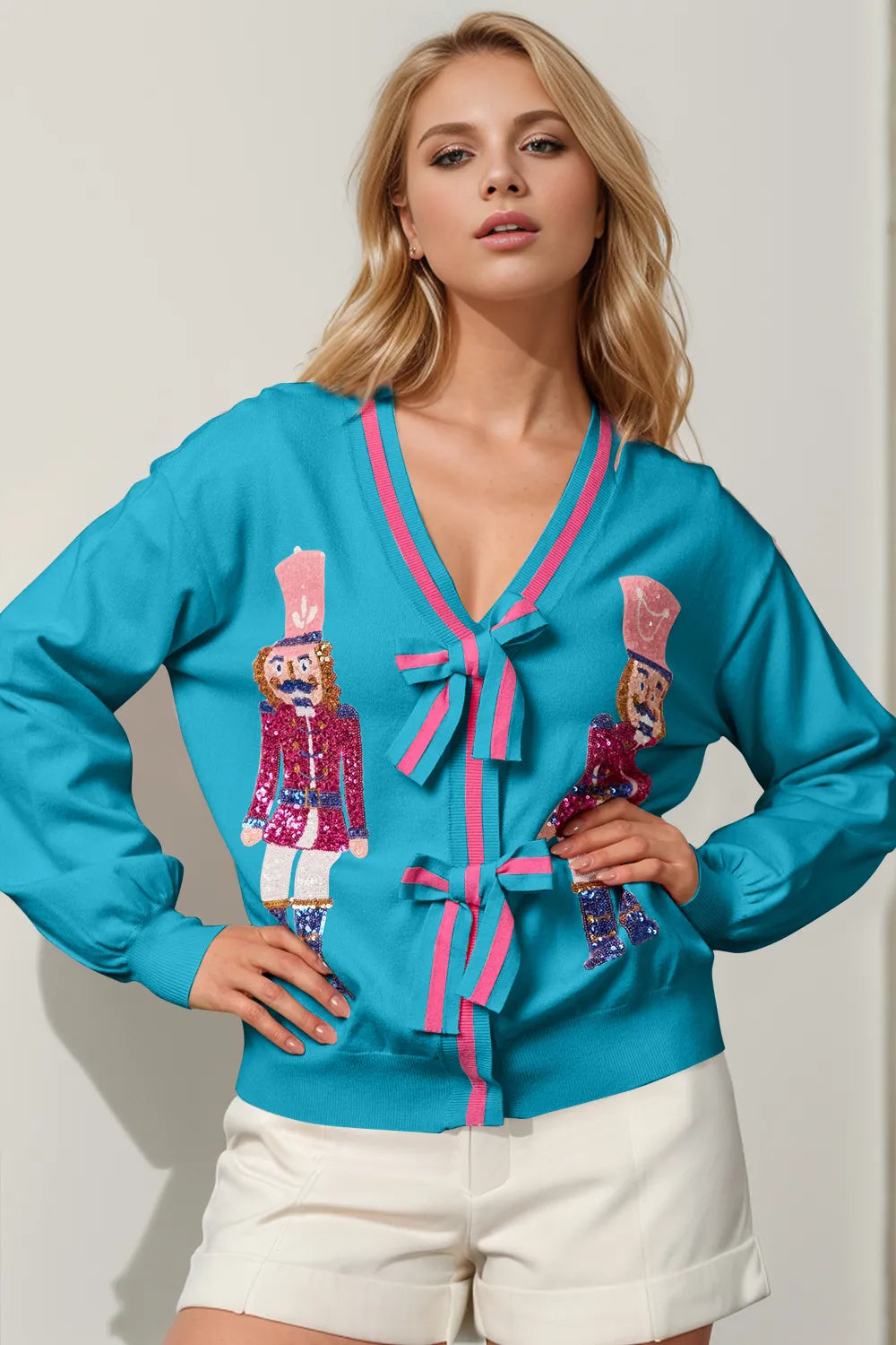Turquoise Christmas cardigan with sequin nutcrackers, V neck and bow closures