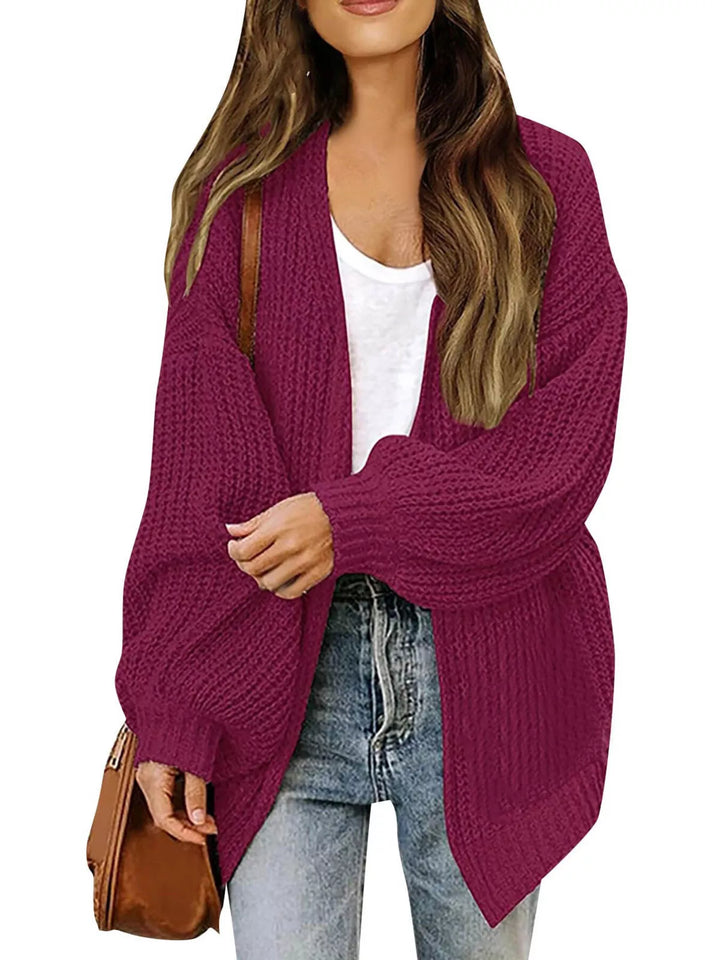 Berry colored chunky knit cardigan worn open over a white tank