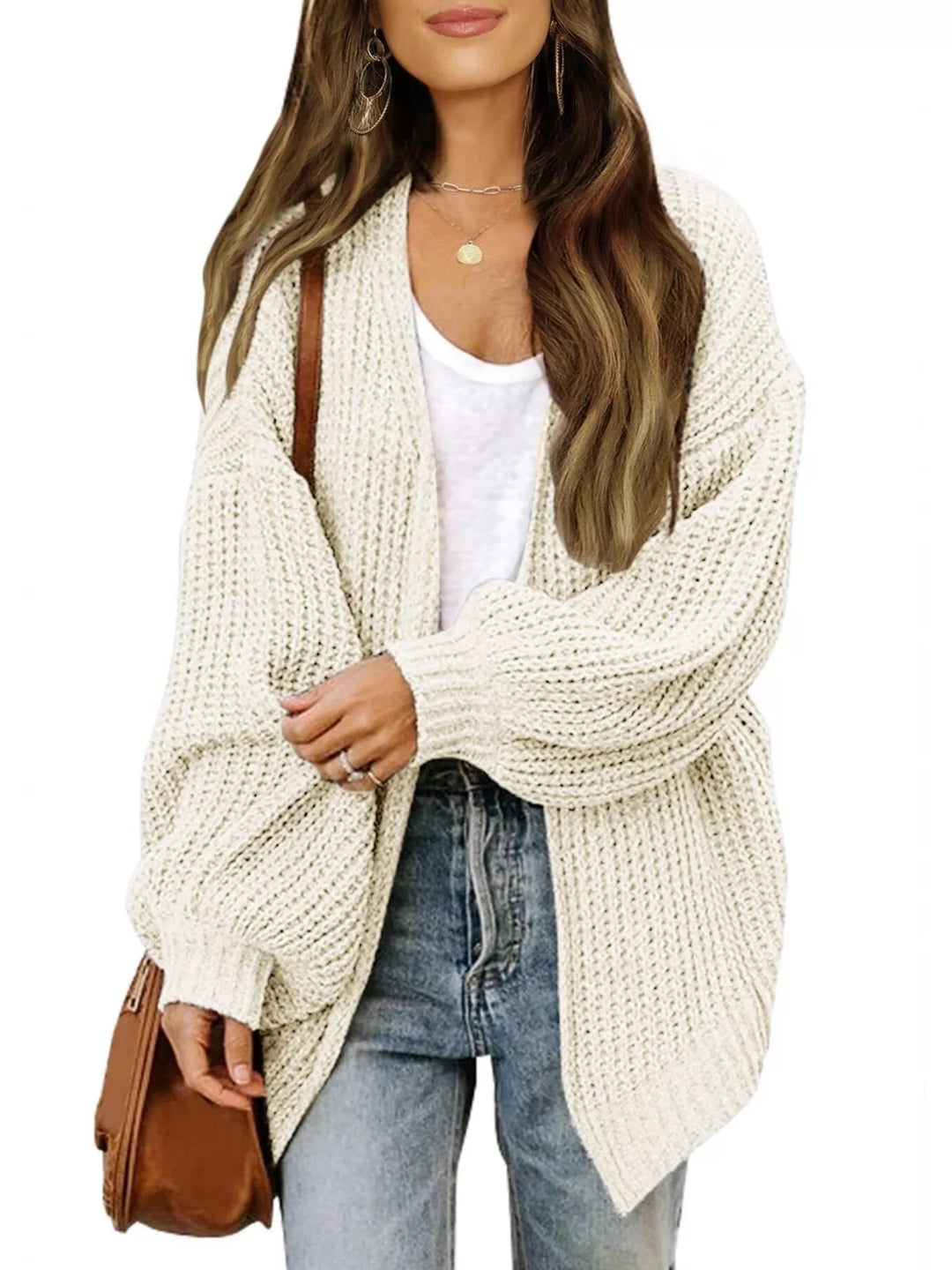 Cream open front cardigan styled with a brown shoulder bag and jeans