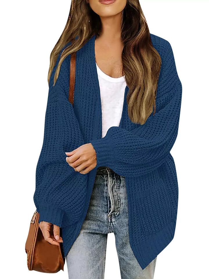 Denim blue chunky knit cardigan worn open over a white tank