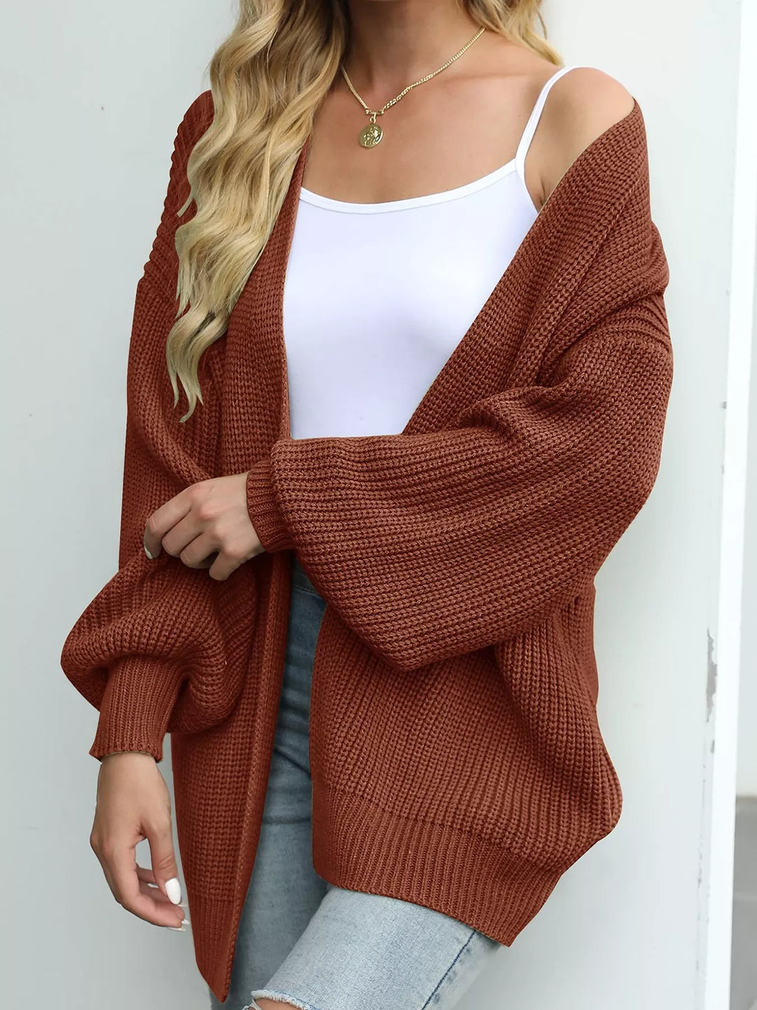 Rust oversized batwing cardigan in a side view with a relaxed sleeve