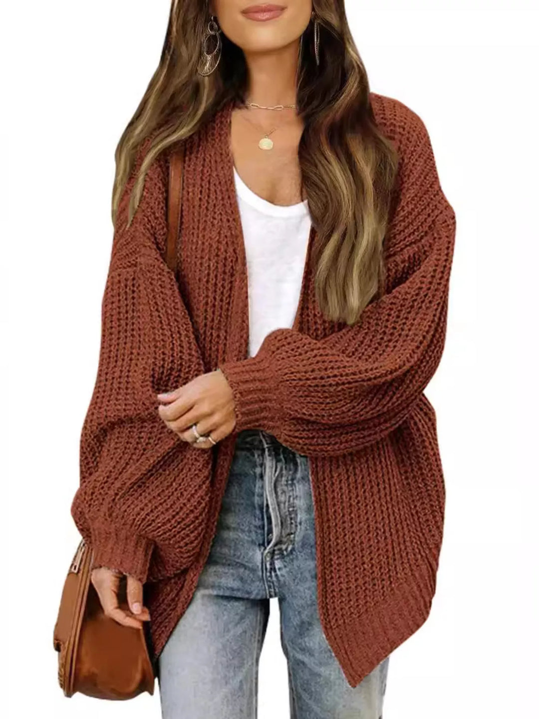 Rust open front cardigan styled with a brown shoulder bag and jeans