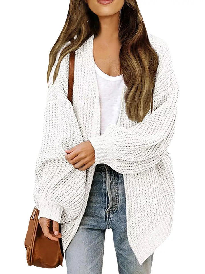 White chunky knit cardigan with batwing sleeves, worn with a brown bag