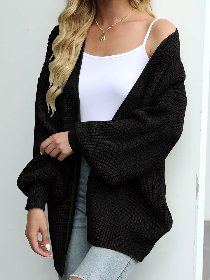 Black oversized open front cardigan with lantern sleeves, angled view