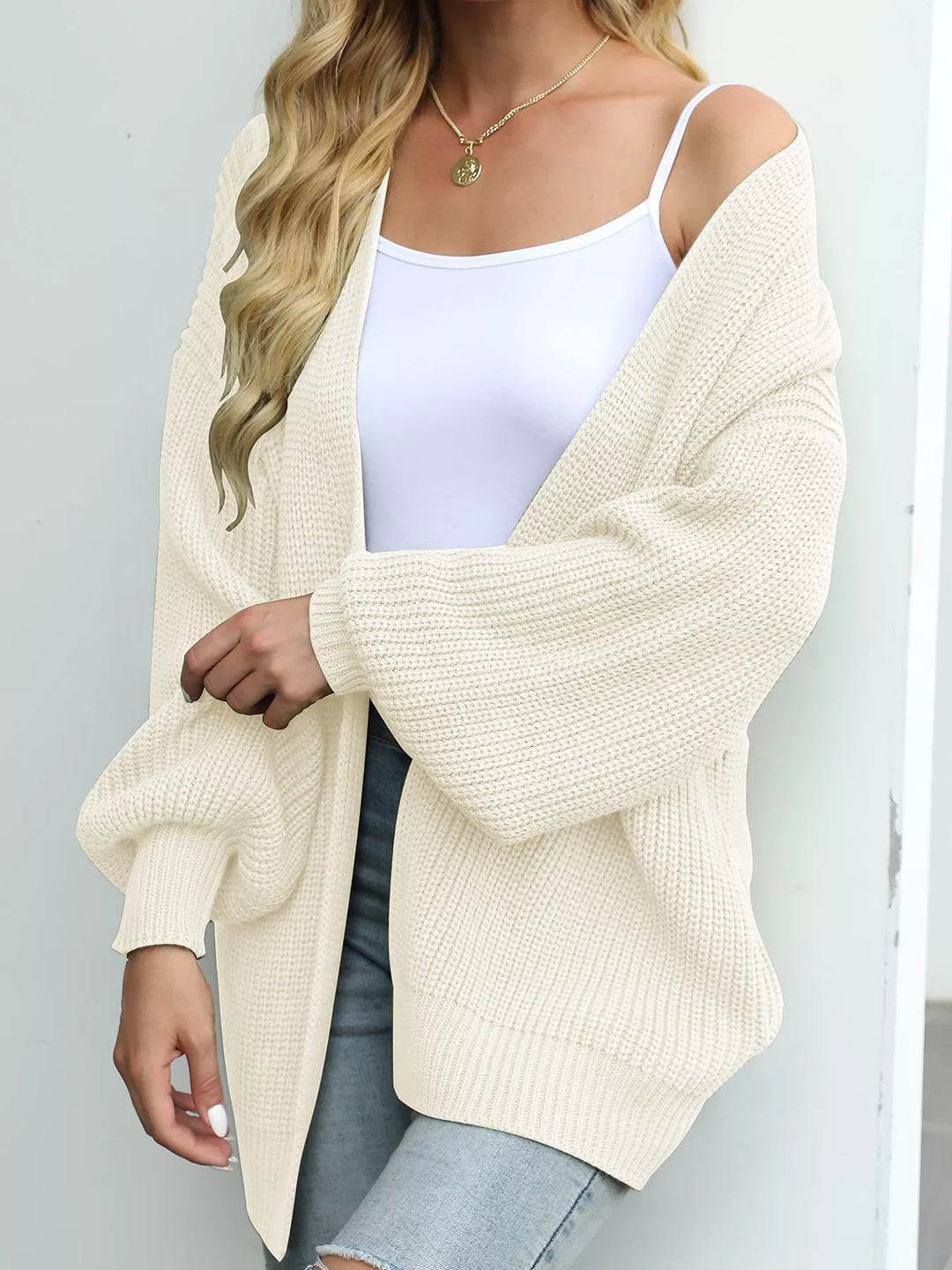 Cream open front cardigan with lantern sleeves, angled view over a white tank
