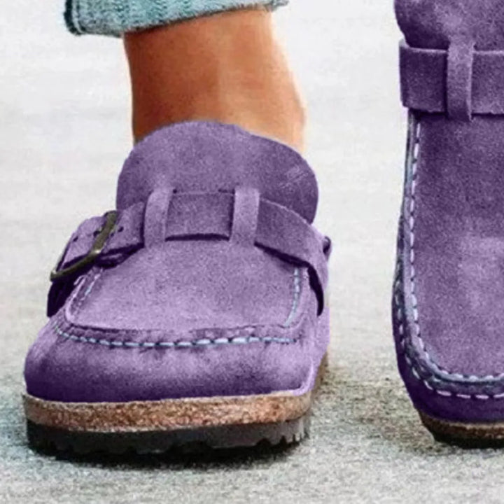 Close-up of the lilac backless clog showing the buckle strap and stitched edge
