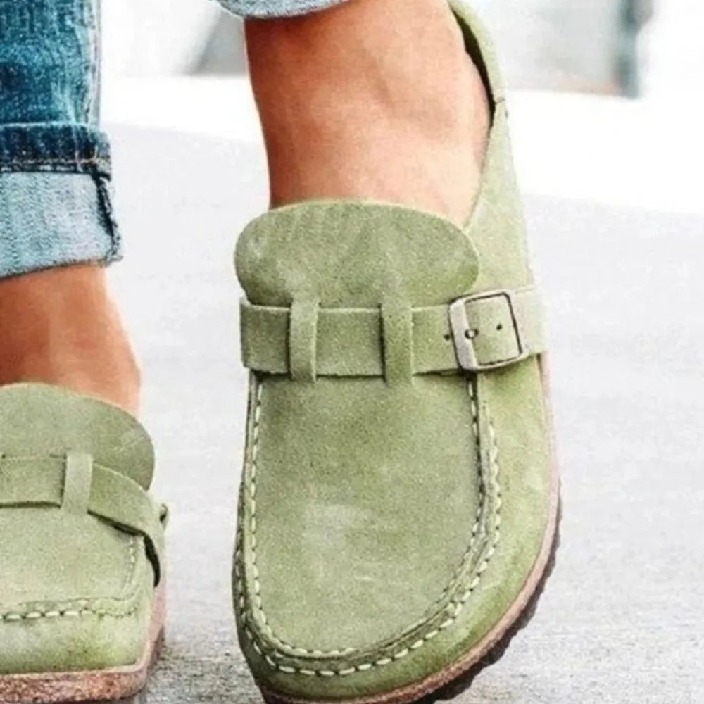 Close-up of the sage slip on clog showing the buckle detail