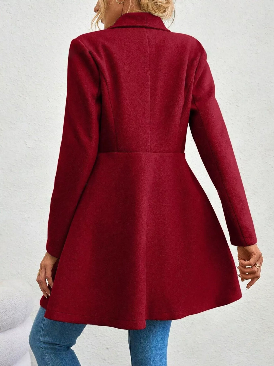 Back view of the burgundy fit and flare coat with waist seam