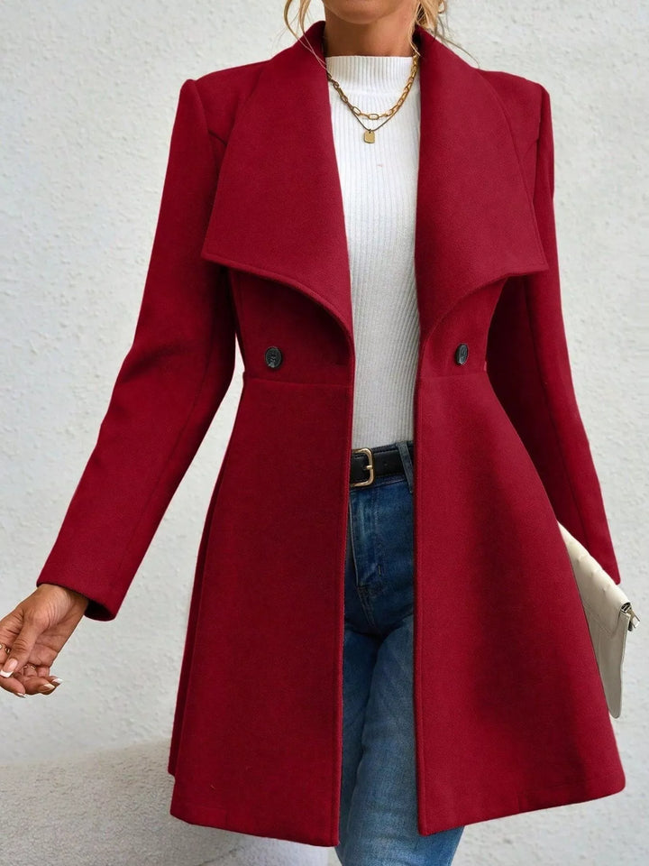 Burgundy fit and flare coat with large lapel, front view with clutch