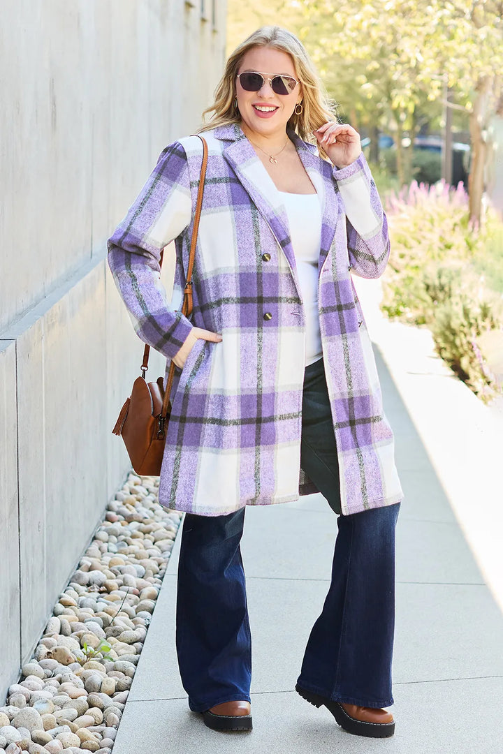 Full length lavender plaid coat with sunglasses and a tan handbag