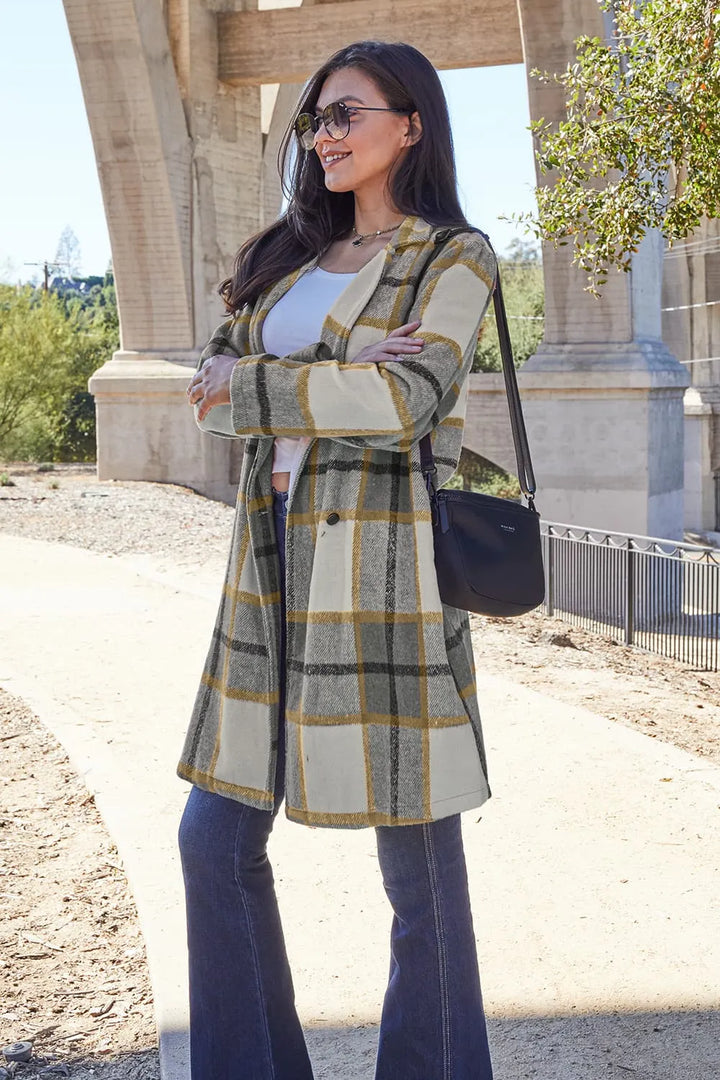 Olive plaid coat styled over a white top with a black shoulder bag
