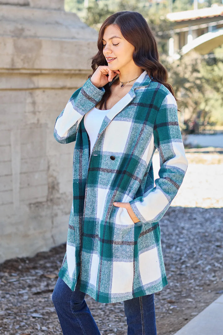 Teal plaid mid length coat side view with hand on lapel