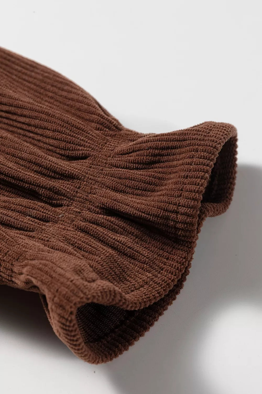 Close-up of the gathered ruffle cuff on the dark brown blouse sleeve