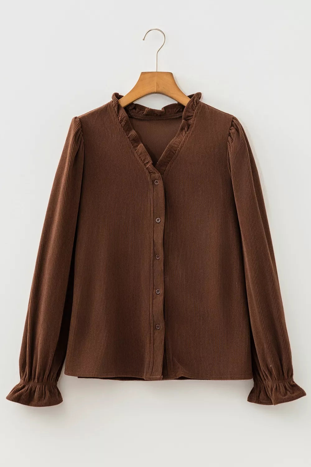 Dark brown corduroy button up blouse hanging on a hanger, front view