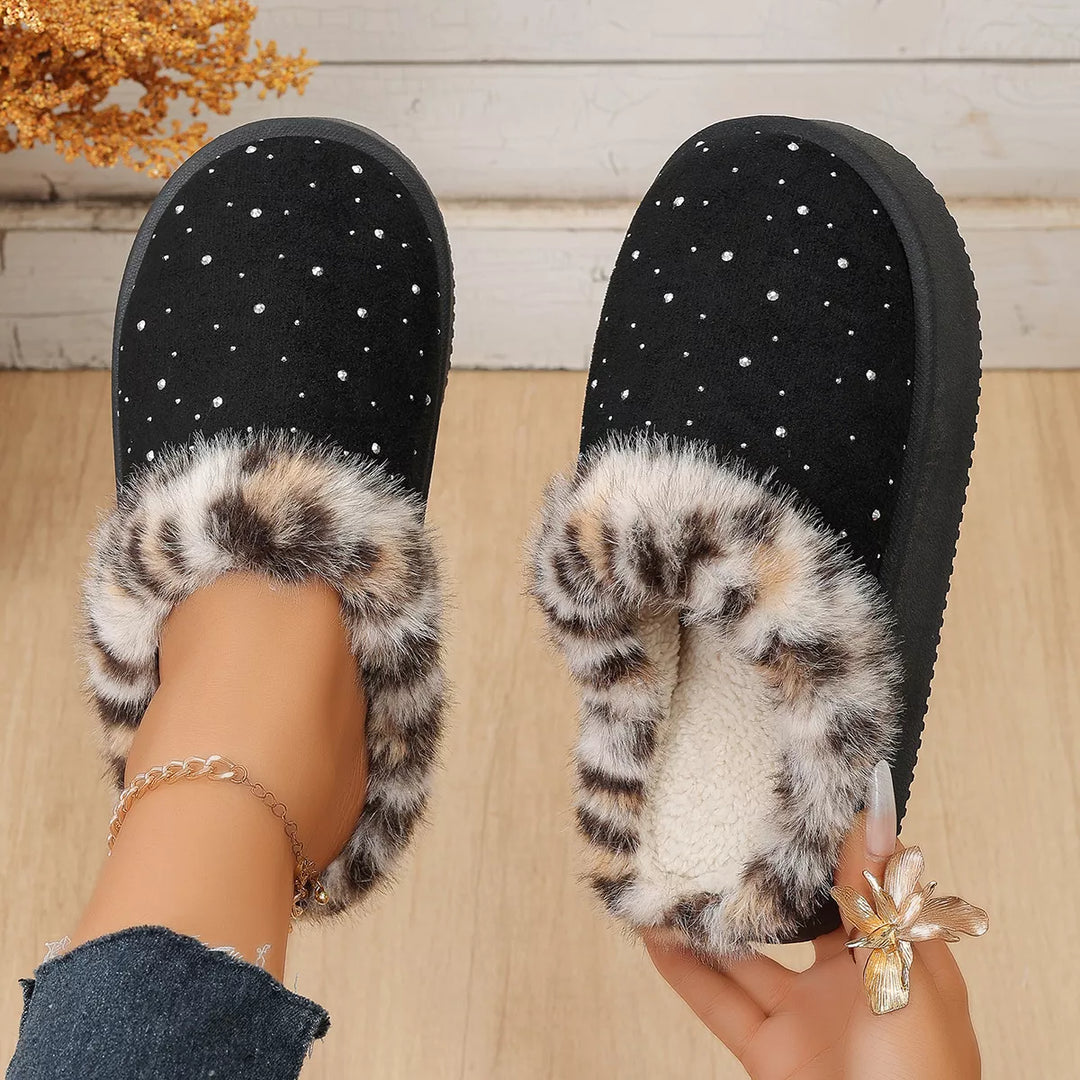 Pair of black cozy slippers, one showing the fluffy leopard print lining
