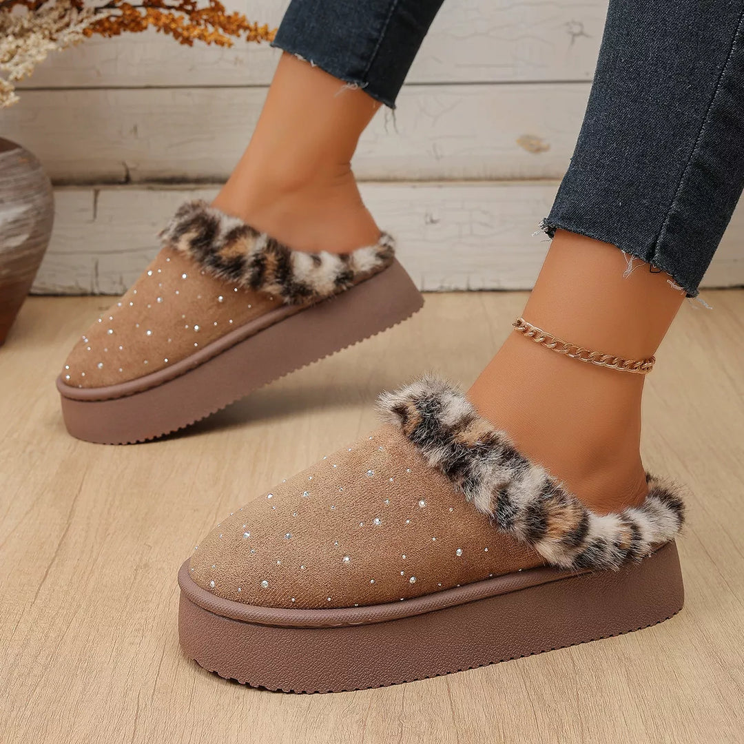 Taupe slip on slippers with sparkly studs, worn on a wood floor