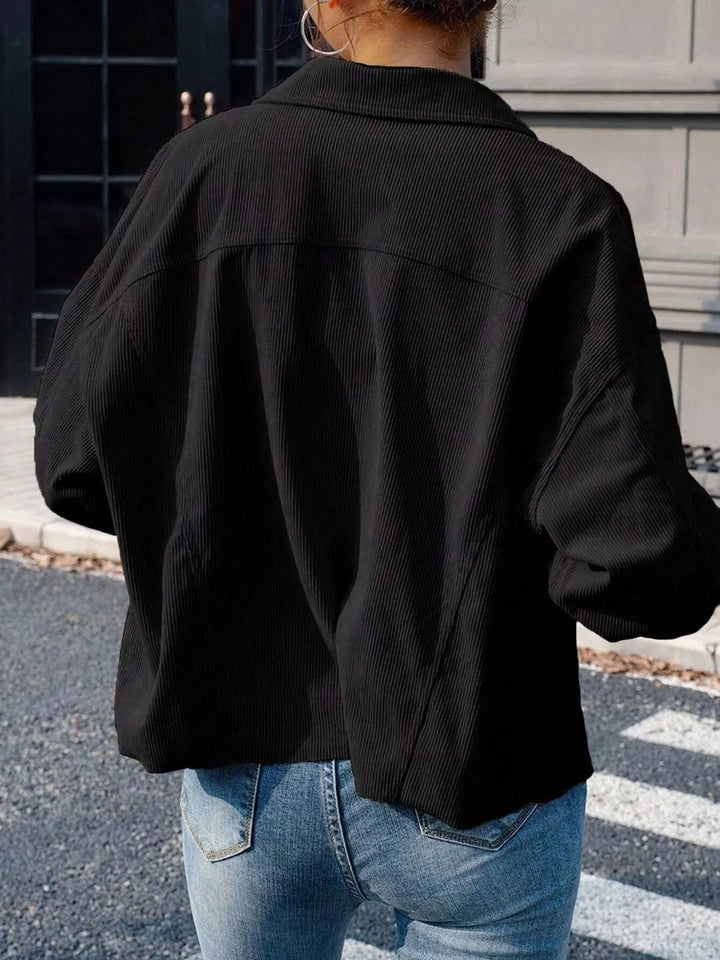 Back view of the black cropped jacket with relaxed sleeves