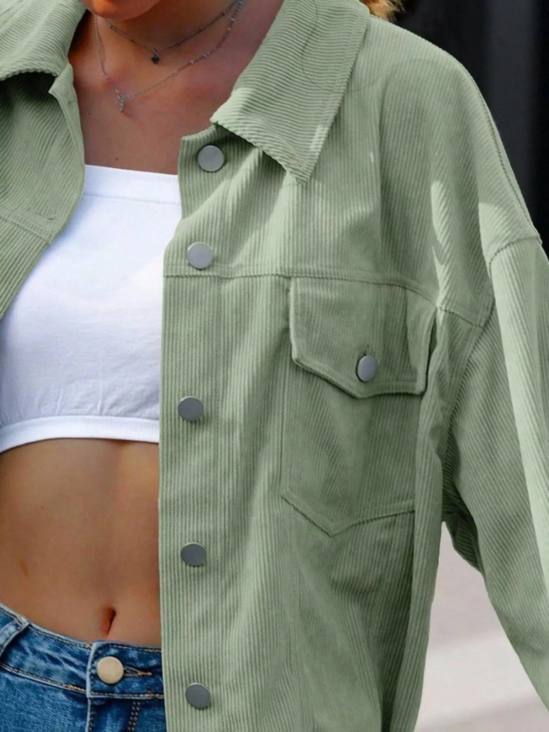 Close-up of the sage green jacket collar, buttons and chest pocket