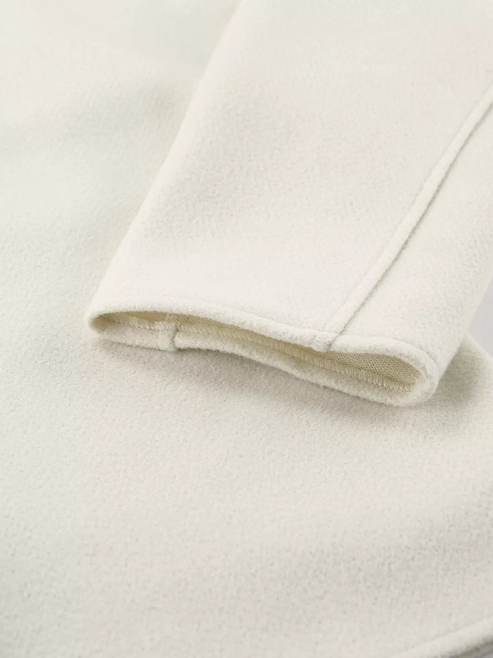 Close-up of the ivory cropped jacket sleeve cuff