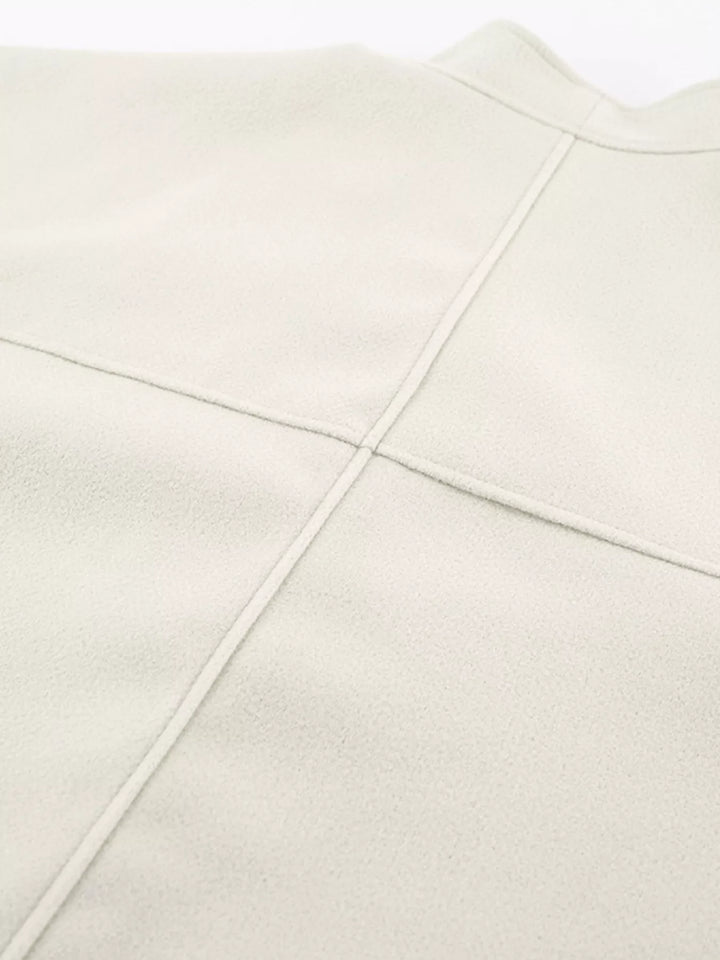 Close-up of the ivory jacket back seam and shoulder