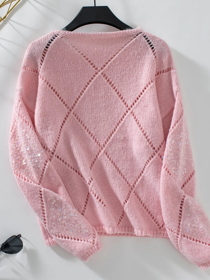 Back of the dusty pink openwork knit sweater on a hanger