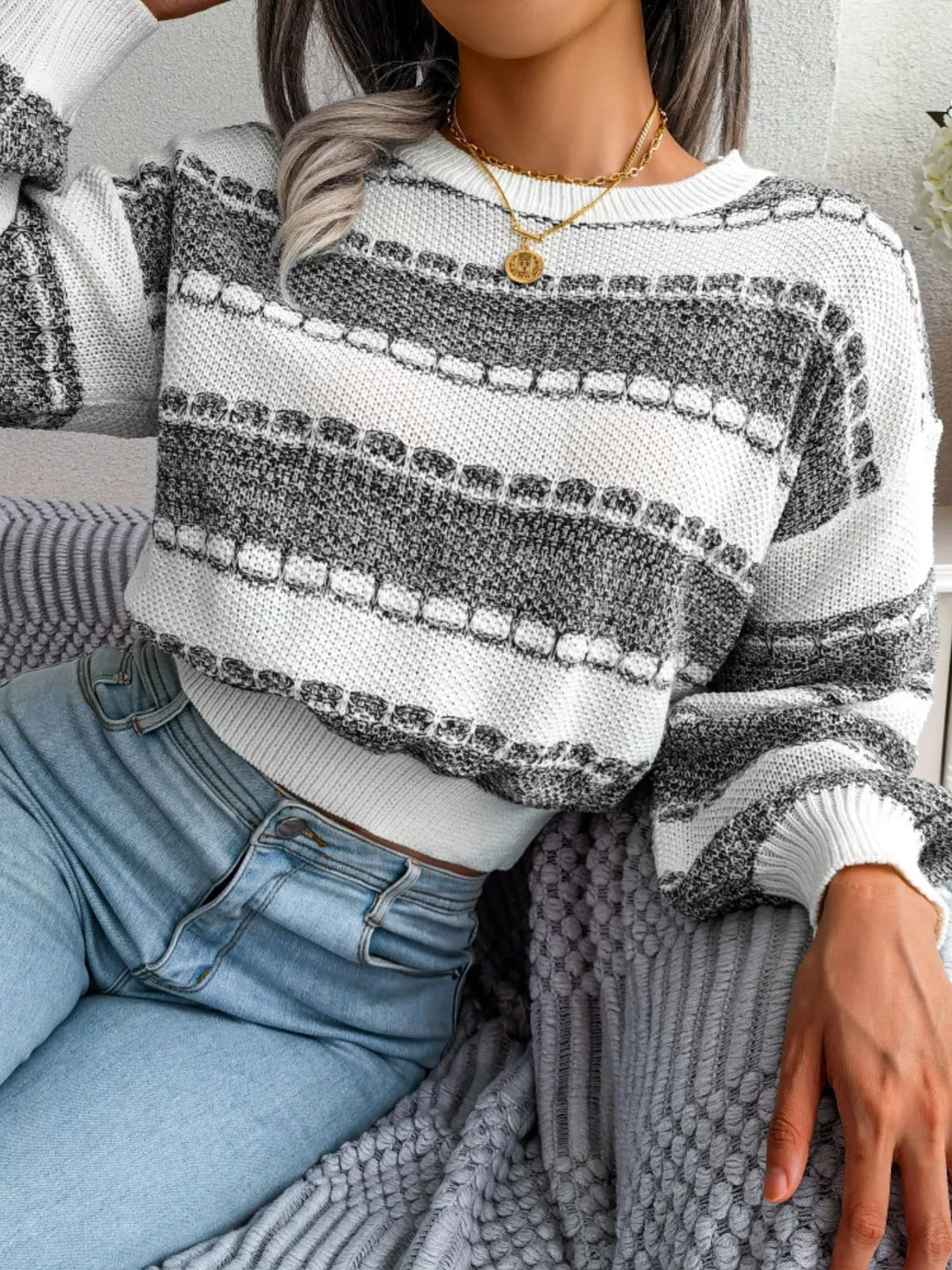 Dark gray wide stripe cropped sweater, seated pose with jeans
