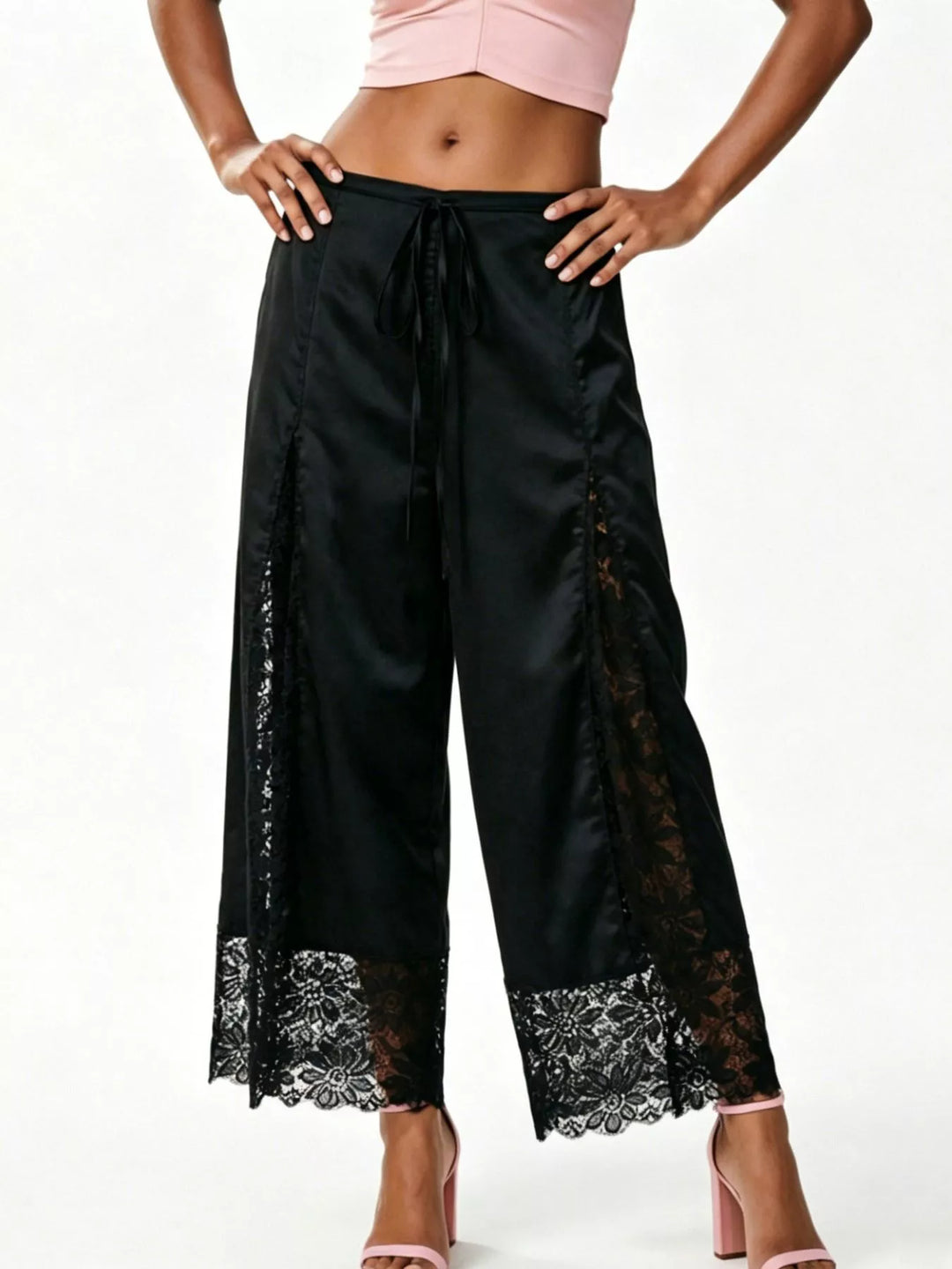Front view of the black cropped lace panel pants with hands on hips
