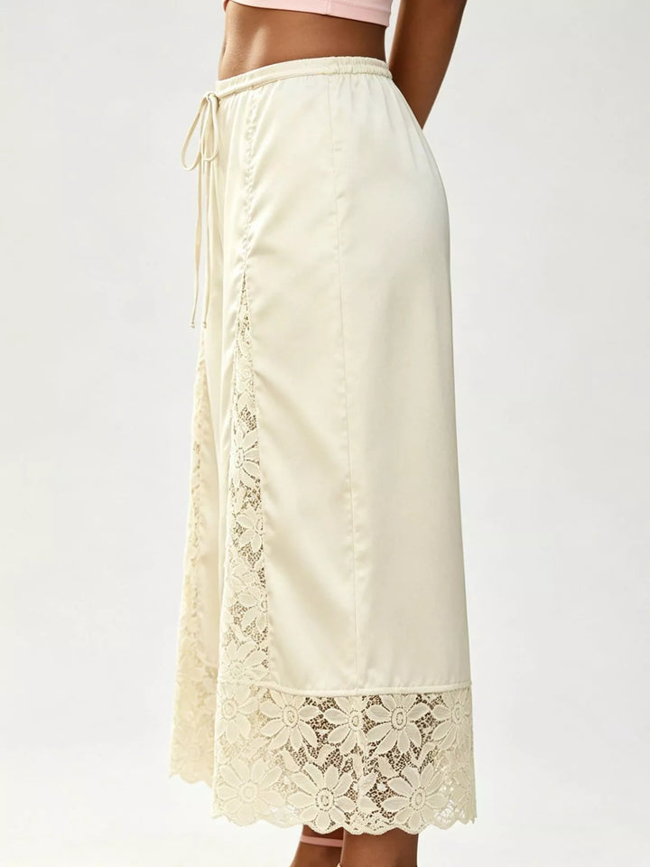 Side view of the champagne satin look pants with a lace trimmed hem