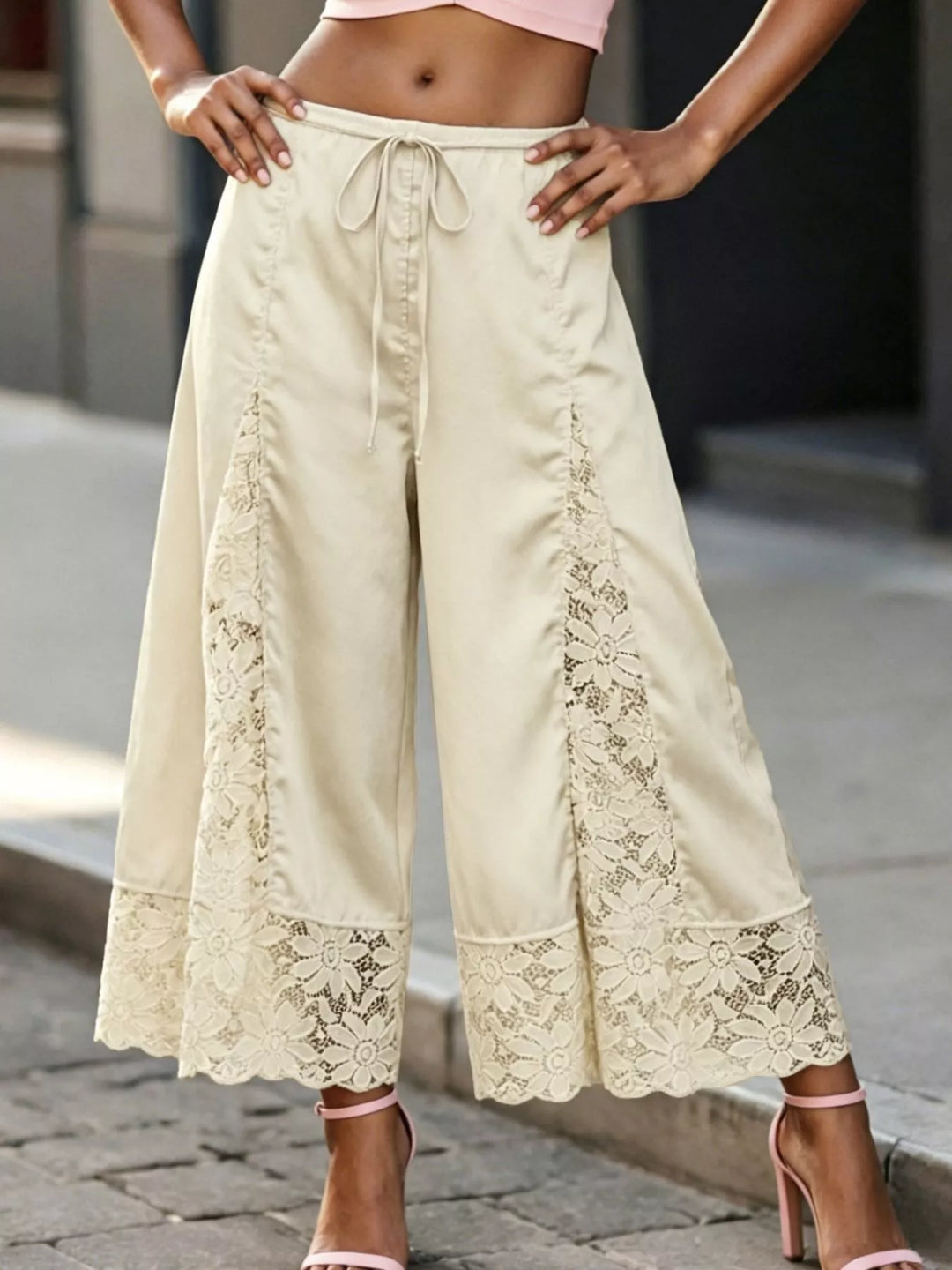 Champagne lace panel pants worn with a pink crop top and hands on hips