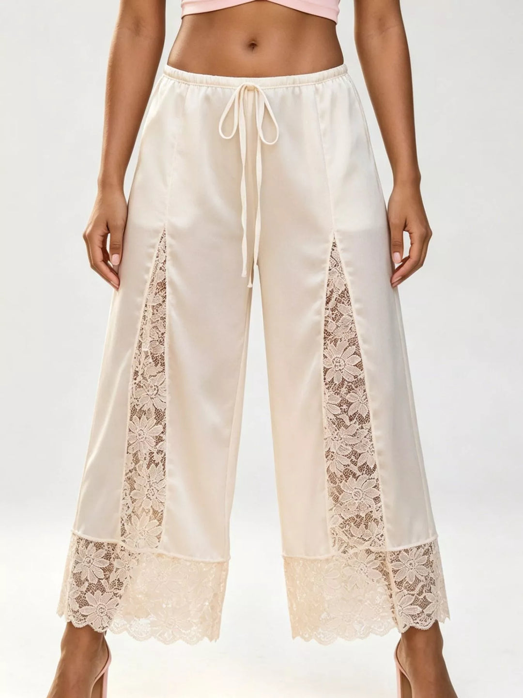 Ivory cropped wide leg pants with lace panels and a drawstring tie waist, front view