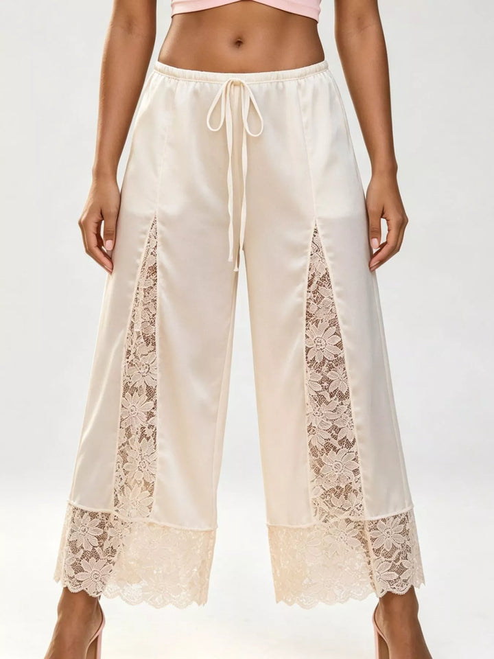 Ivory cropped wide leg pants with lace panels and a drawstring tie waist, front view