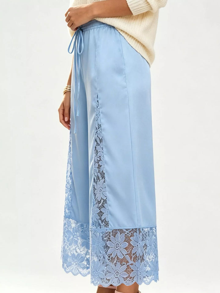 Side view of the light blue wide leg pants showing the lace panel and scalloped hem