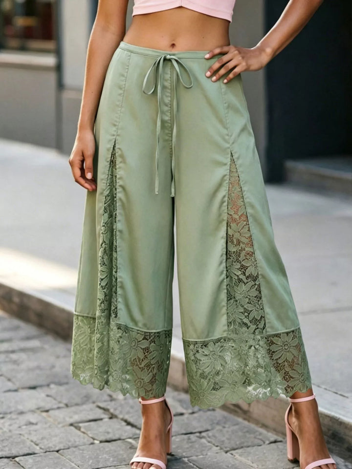 Full-length sage green satin look pants with lace panels and scalloped hem