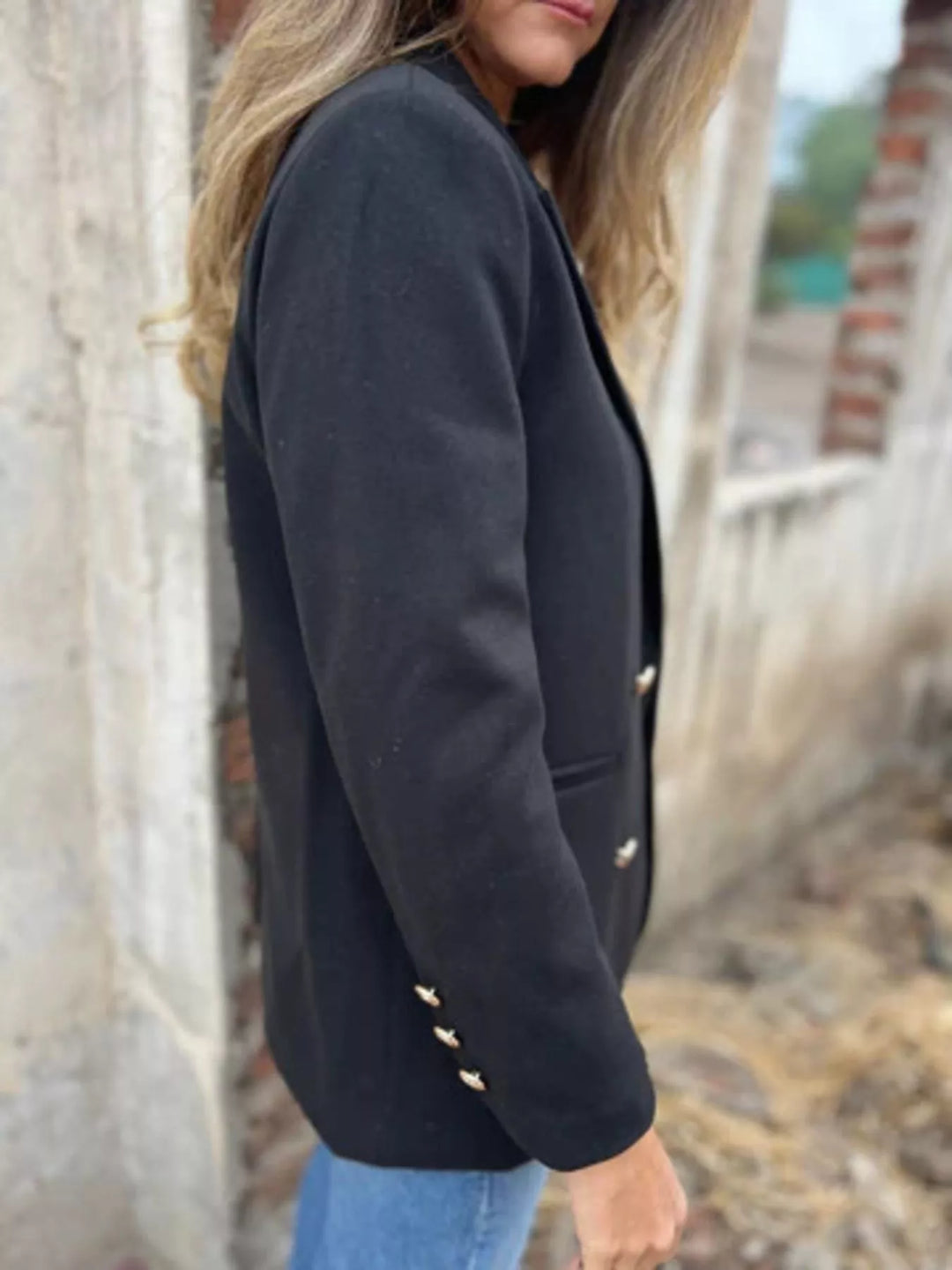 Side view of the black double breasted blazer showing the button cuff