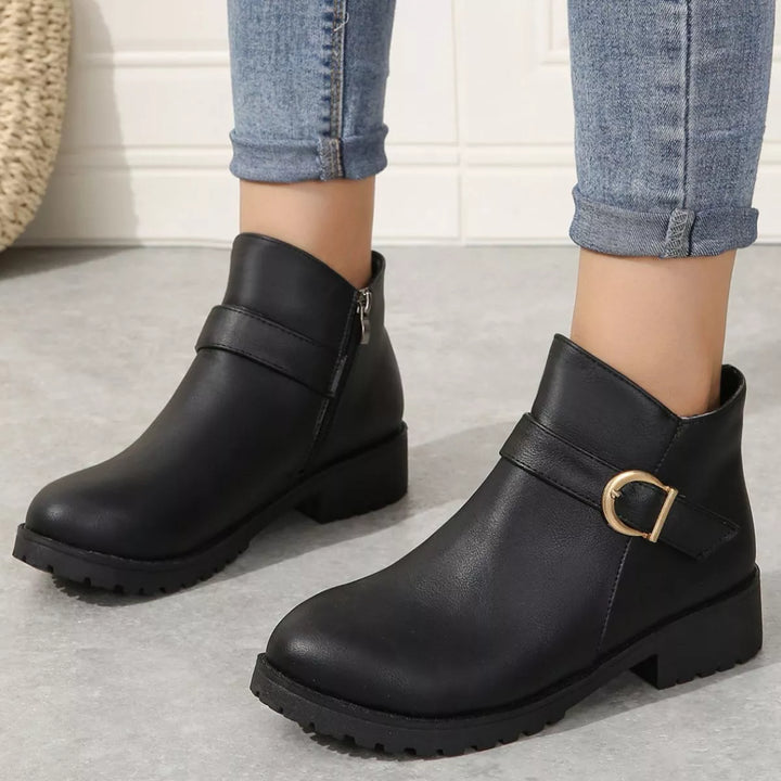 Black buckle ankle boots with low block heel, front view styled with cuffed jeans