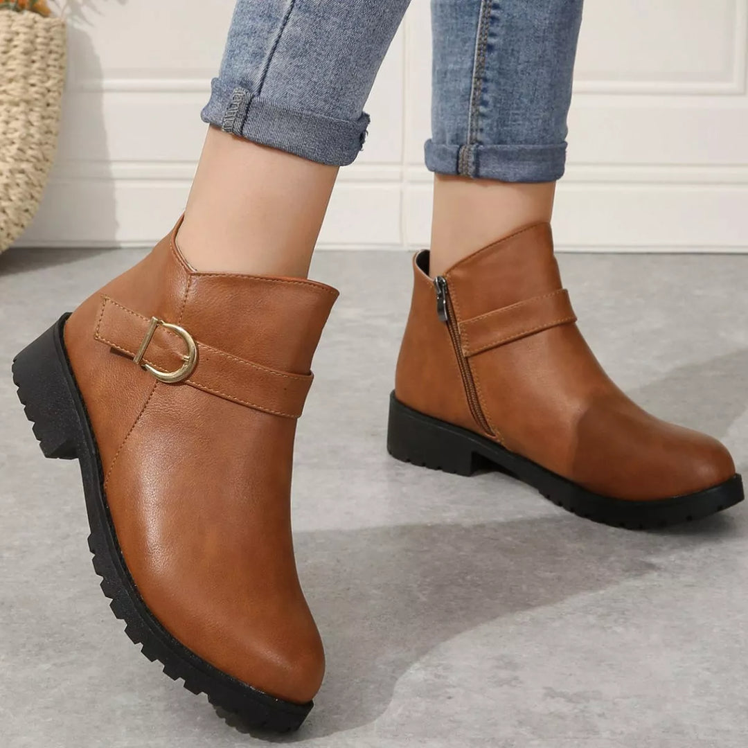 Cognac buckle ankle boots styled with light wash jeans, angled front view