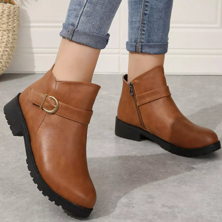 Cognac buckle ankle boots styled with light wash jeans, angled front view