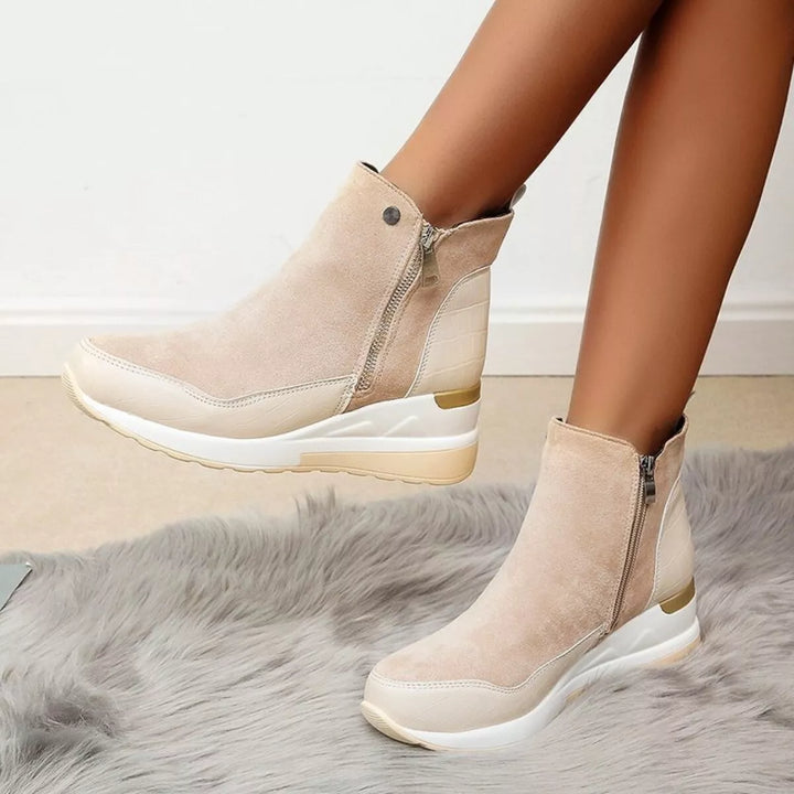 Beige chunky wedge ankle boots, one lifted to show the platform sole
