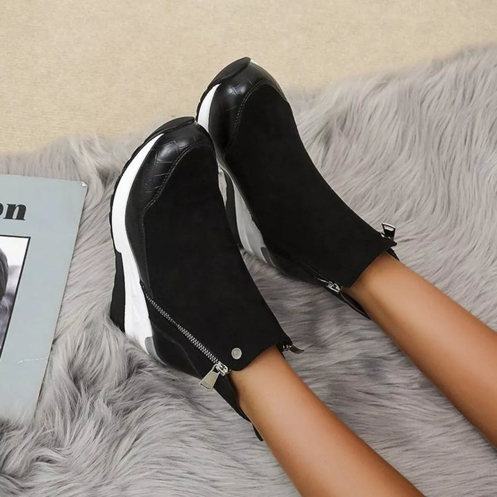 Black chunky wedge boots seen from above on a gray fur rug