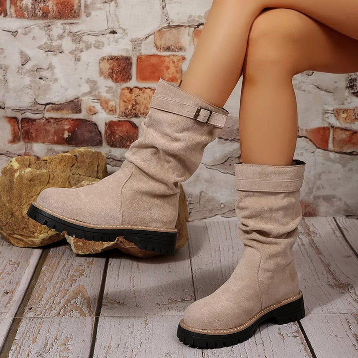 Taupe chunky sole boots worn with legs crossed