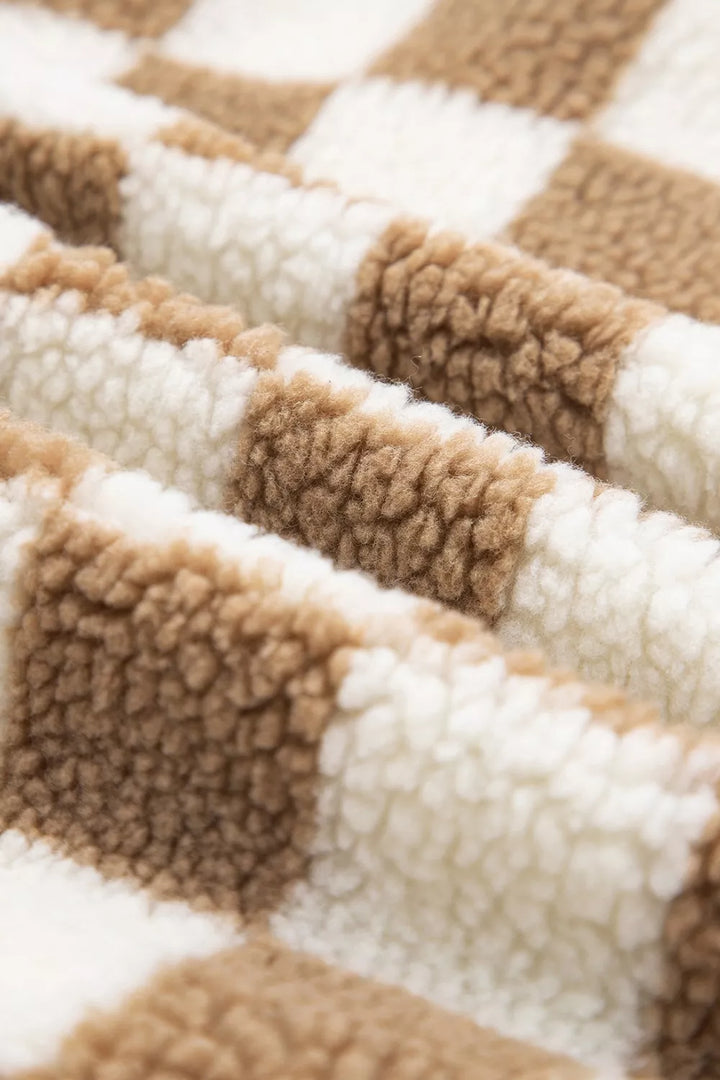 Folded plush checkerboard fabric in brown and cream, close-up of the texture