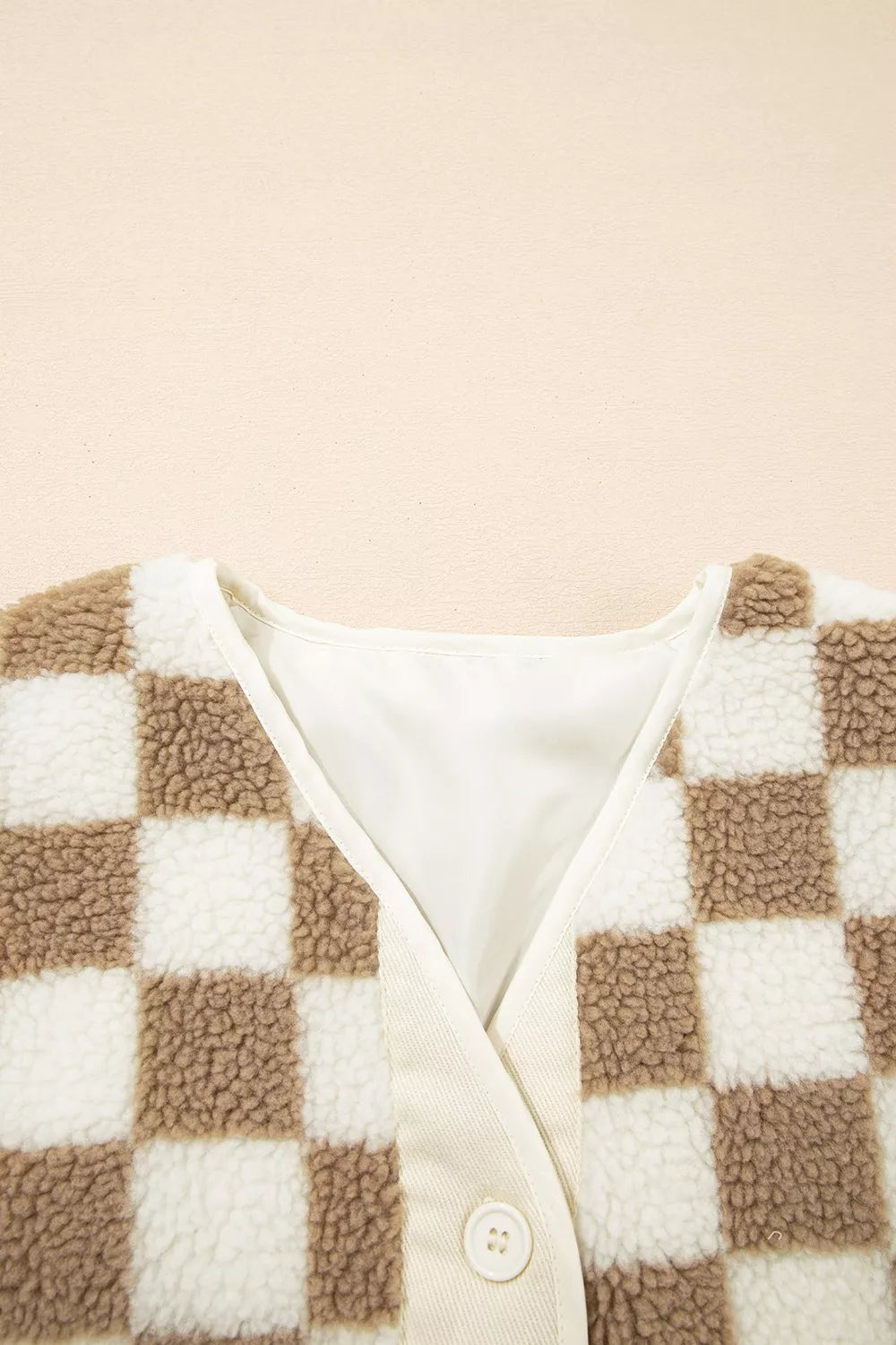 Detail of the V neckline and cream trim on the checkerboard jacket