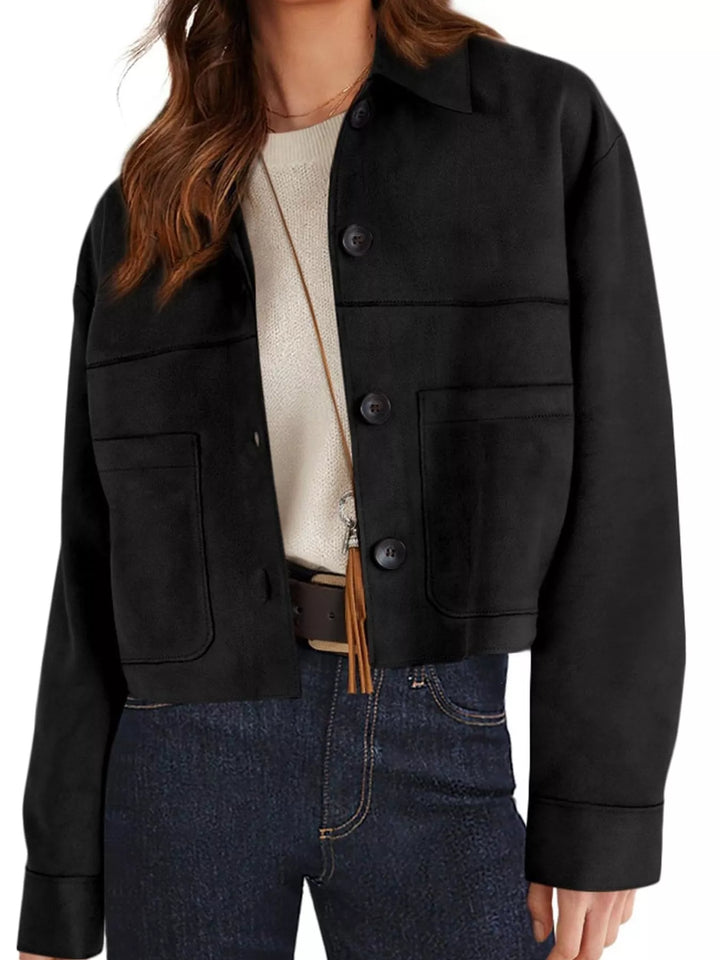 Black cropped jacket worn over a white tee and dark jeans