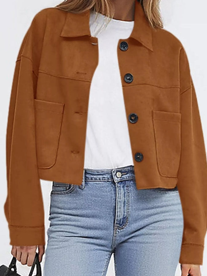 Cropped caramel jacket styled with jeans and a black handbag