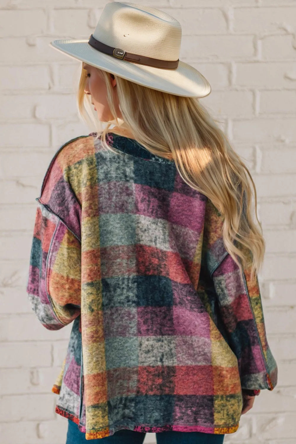 Back view of the multicolor patchwork plaid shacket worn with a straw hat