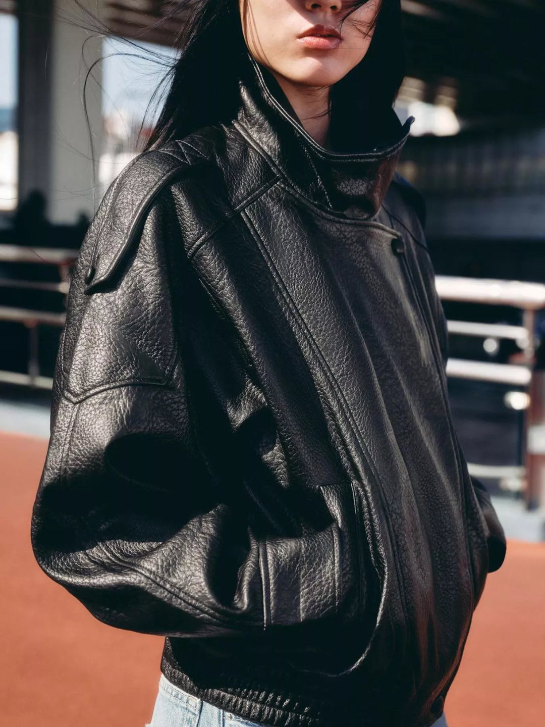 Black oversized moto jacket with hands in pockets and elastic hem