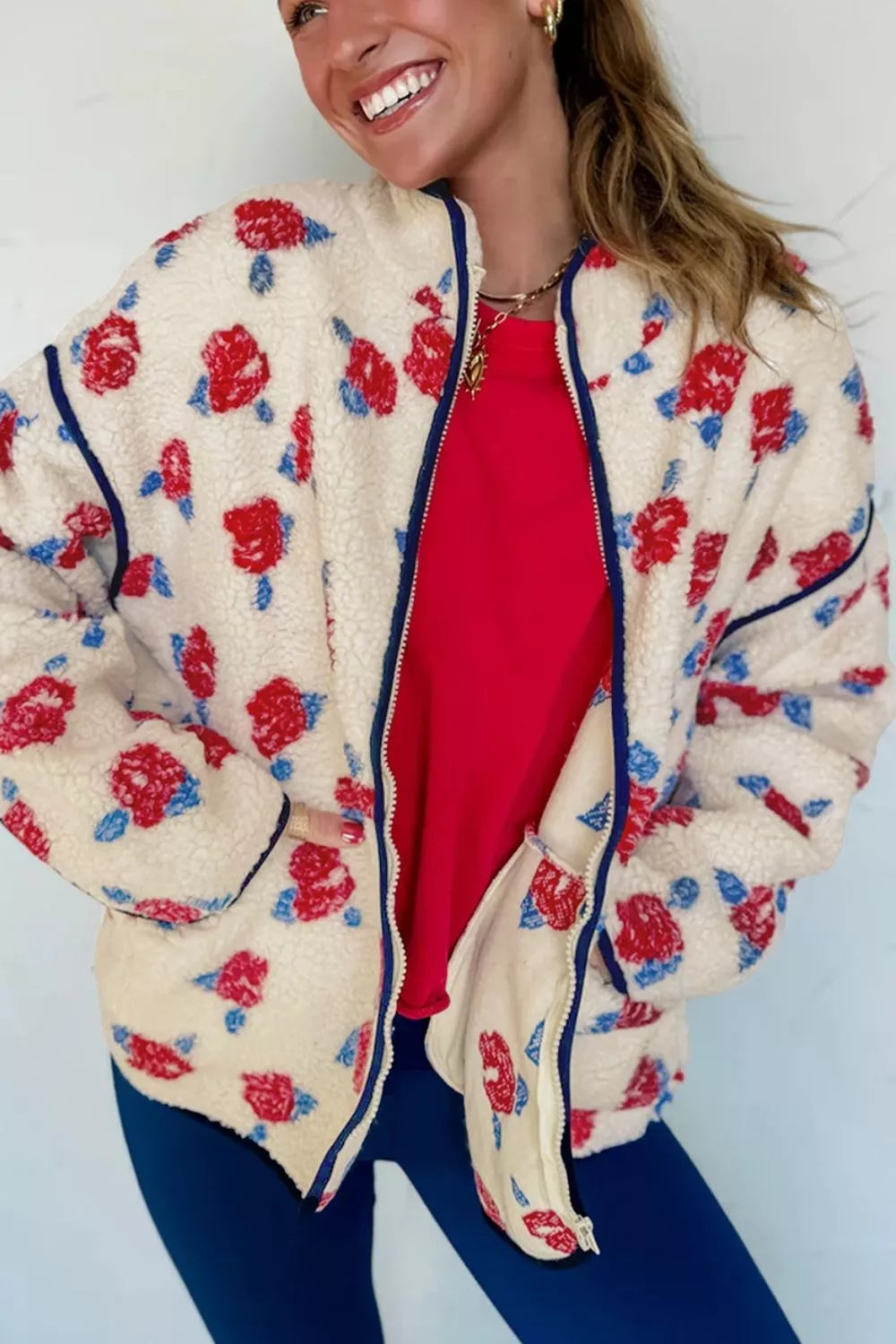 Rose print stand collar jacket worn open with hands in pockets, smiling pose