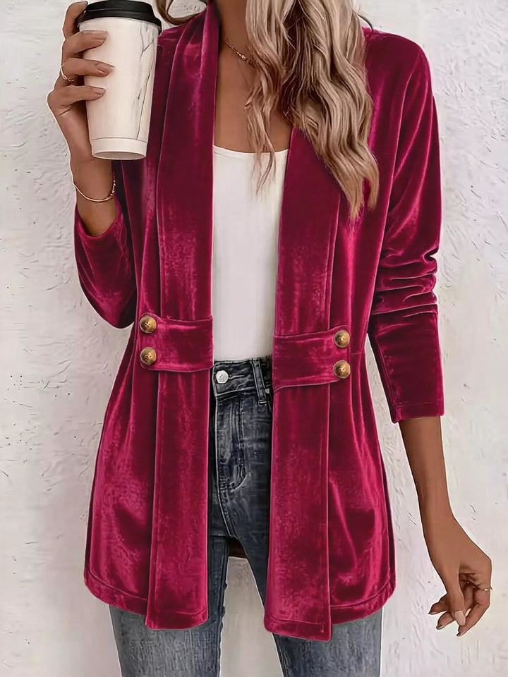 Berry colored velvet-look jacket with shawl collar and gold buttons, holding a coffee